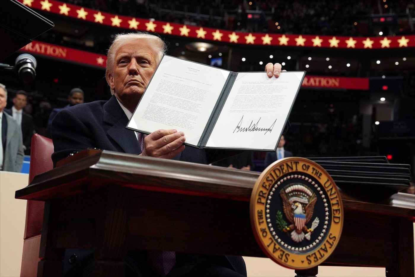 President Trump holding a signed presidential action